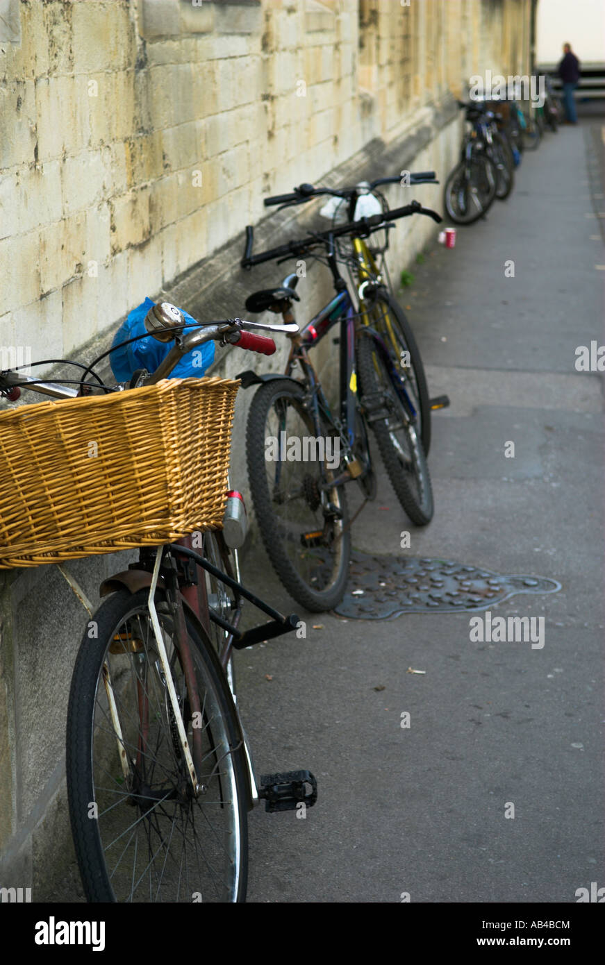Row of black bicycles parked on pavement against building along street Oxford England Stock Photo