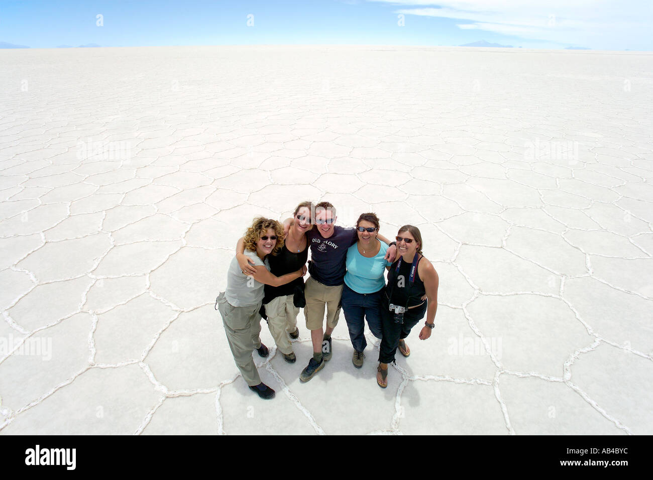 A wide angle overhead view of a group of tourists posing on the Bolivian Salt Flats (Salar de Uyuni). Stock Photo