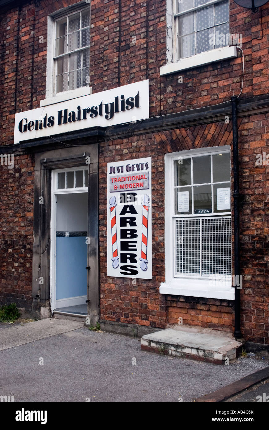 Gents Hairdressers in Birkenhead Merseyside UK May 2007Advertising traditional and modern haircuts from a terraced shop Stock Photo