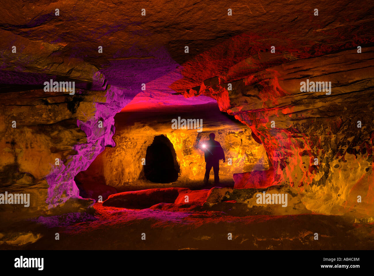 Man exploring sandstone cave in Cheshire UK Stock Photo