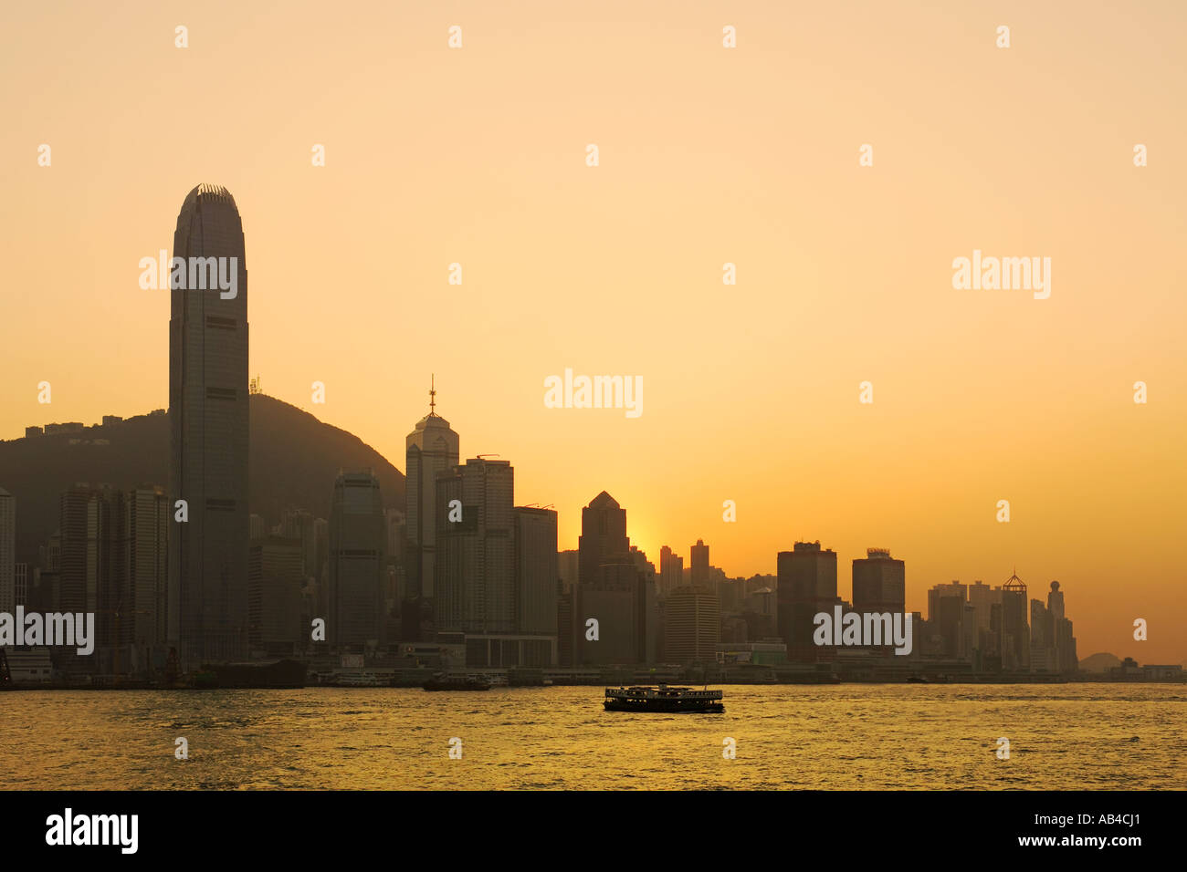 A sunset view of skyscrapers on Hong Kong Island over Victoria Harbour with the IFC building (tallest in Hong Kong) left. Stock Photo