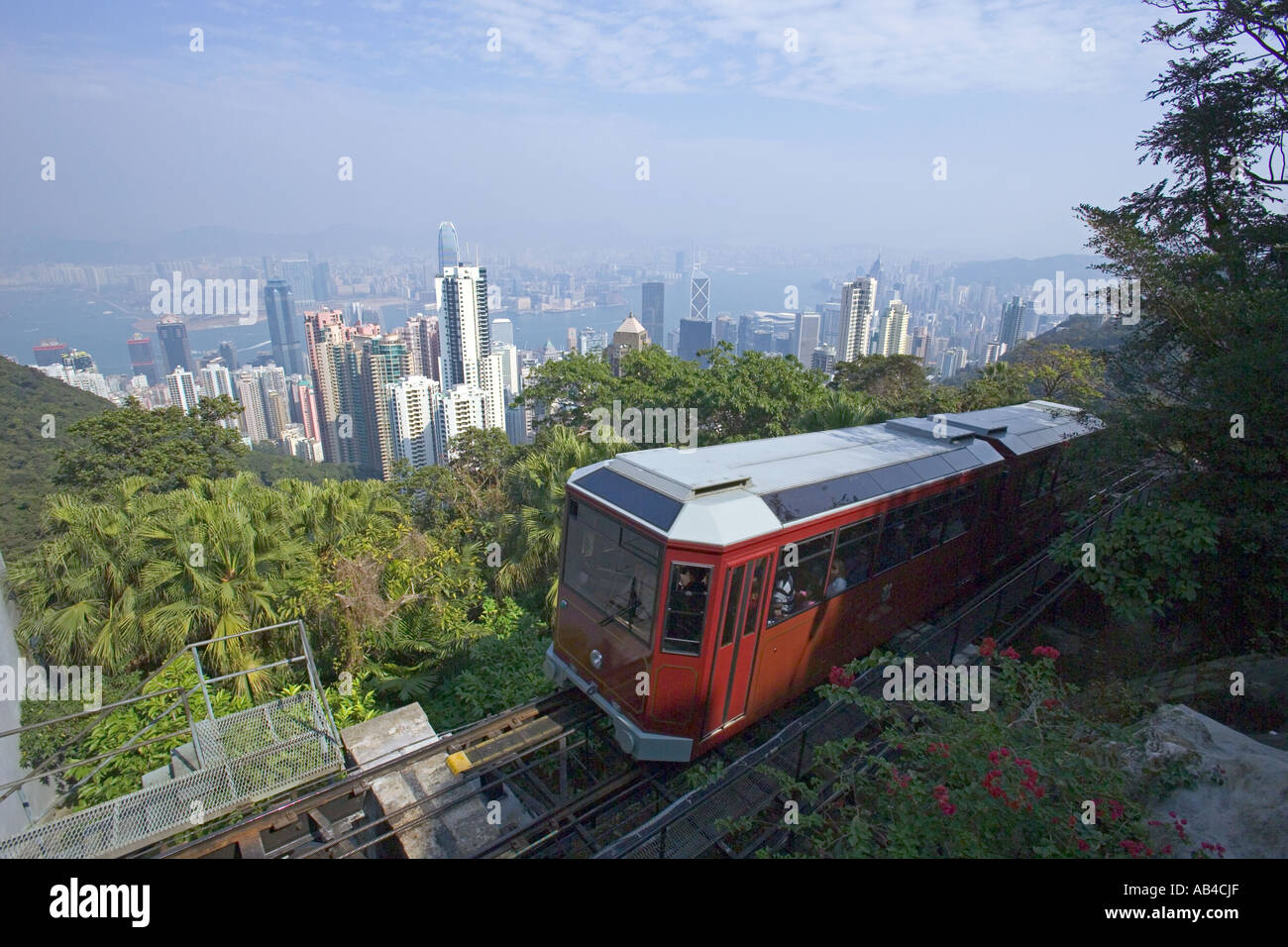 An aerial view over Hong Kong and Victoria Harbour with the Peak Tram a few meters from the upper station of Victoria Peak. Stock Photo