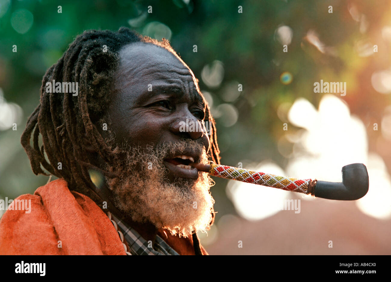 Portrait shot of a colourful tribal elder smoking an elaborate pipe. Stock Photo