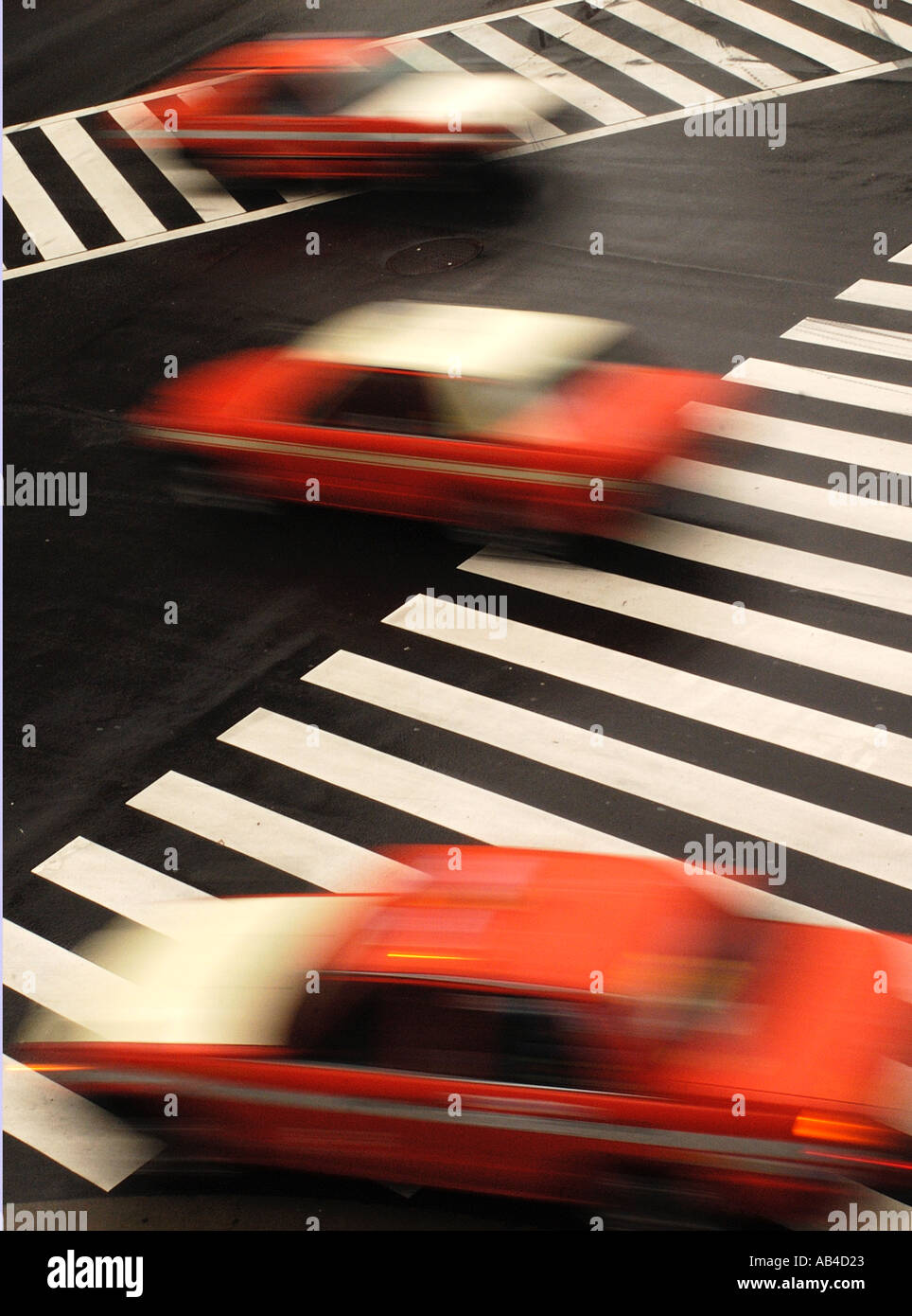 Red Tokyo taxis speeding across an intersection in Tokyo Japan Stock Photo