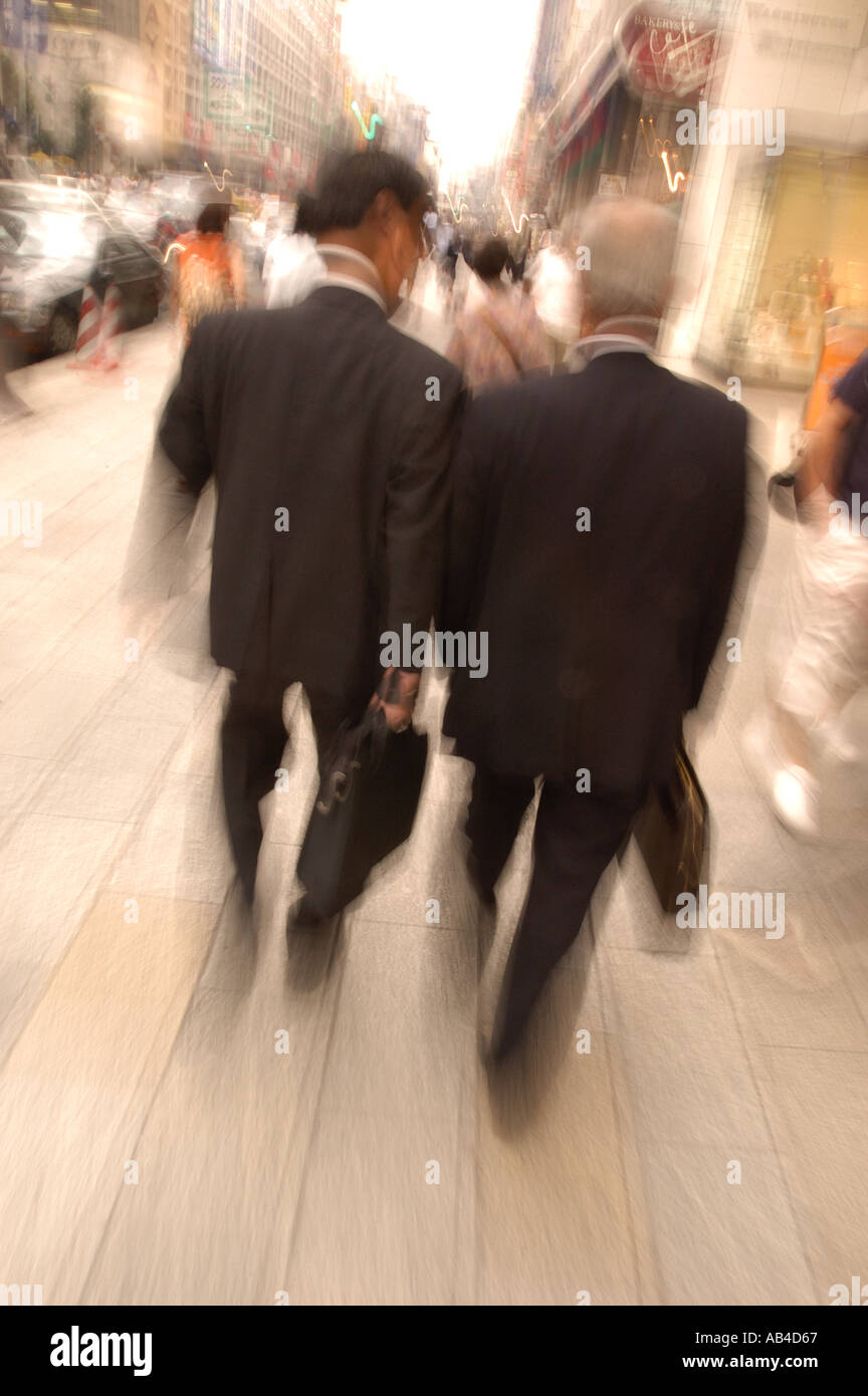 Businessmen walking on street with blurred slow shutter speed in Tokyo Japan Stock Photo