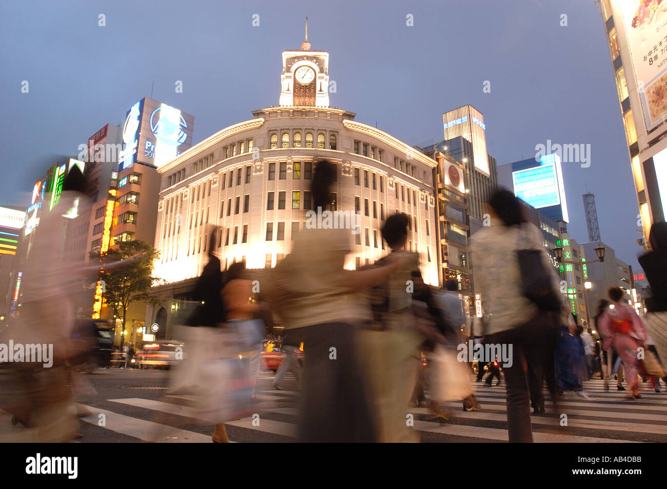 Evening crowds on the streets of Ginza Tokyo with Wako Department store in rear Japan Stock Photo