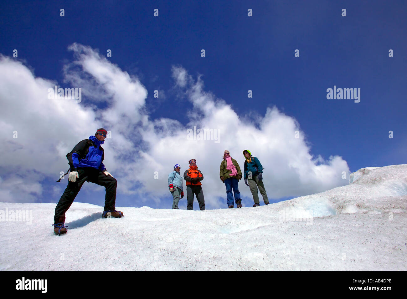 A group of tourists pose for the camera while on a glacier walking trip on the Viedma Glacier. Stock Photo
