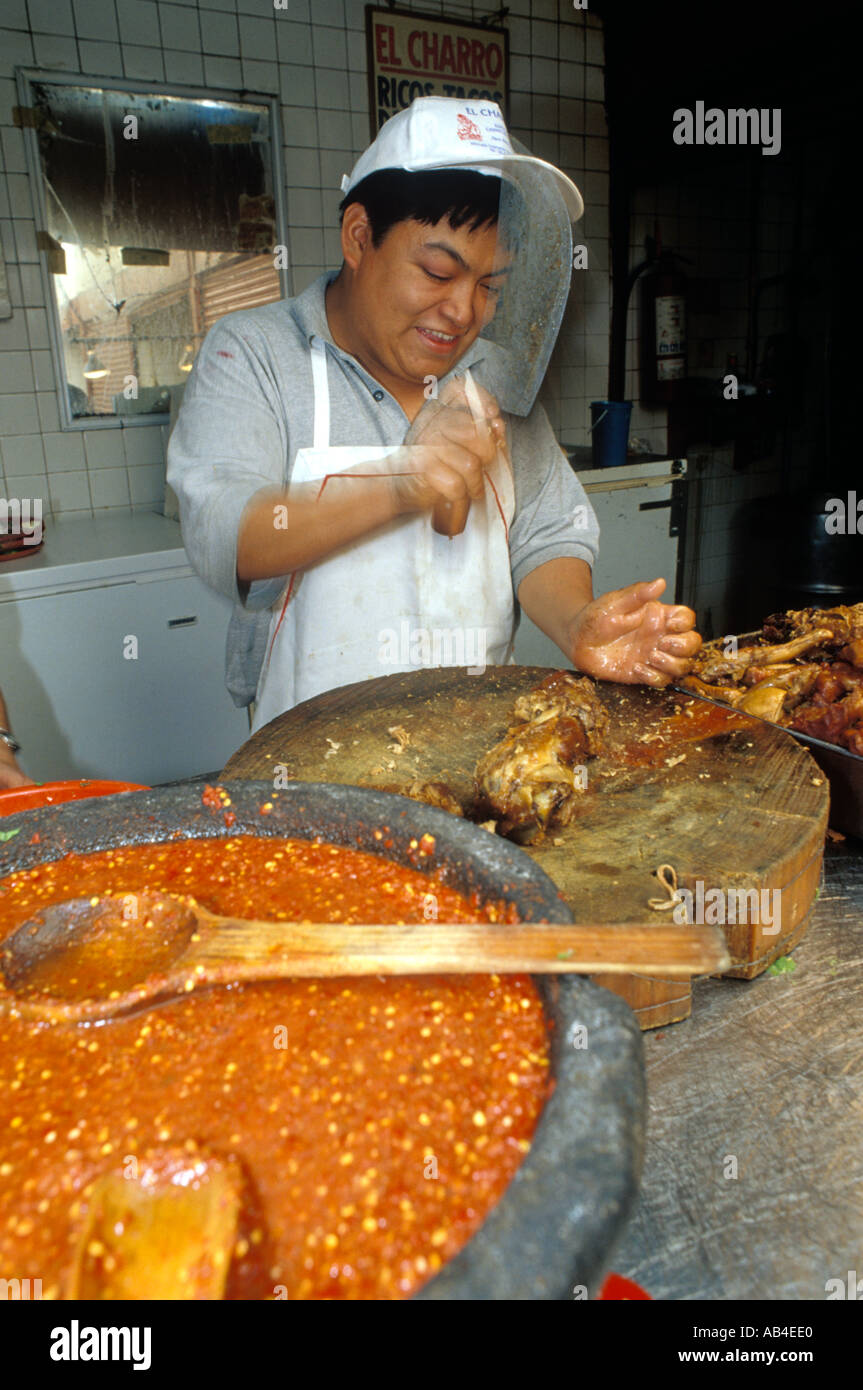 Chopping barbacoa baked goat meat for tacos at the Coyoacan Market in