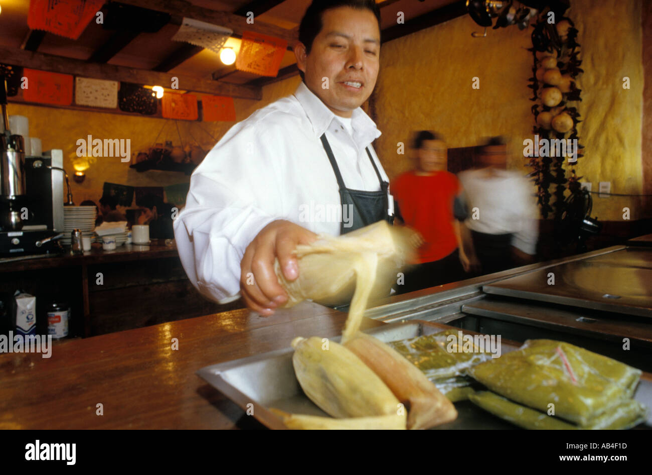 A waiter serves a traditional Mexican cornmeal dish a tamale at a A waiter serves a traditional Mexican cornmeal dish a tamale at a