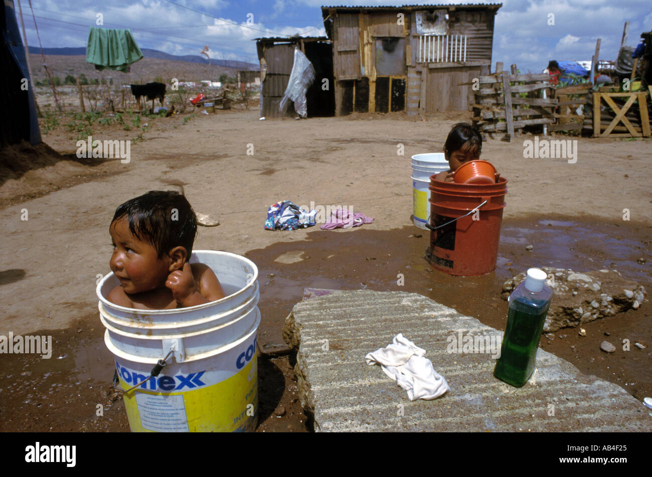 Two young boys take a bath in tubs at a squatters camp in San Luis