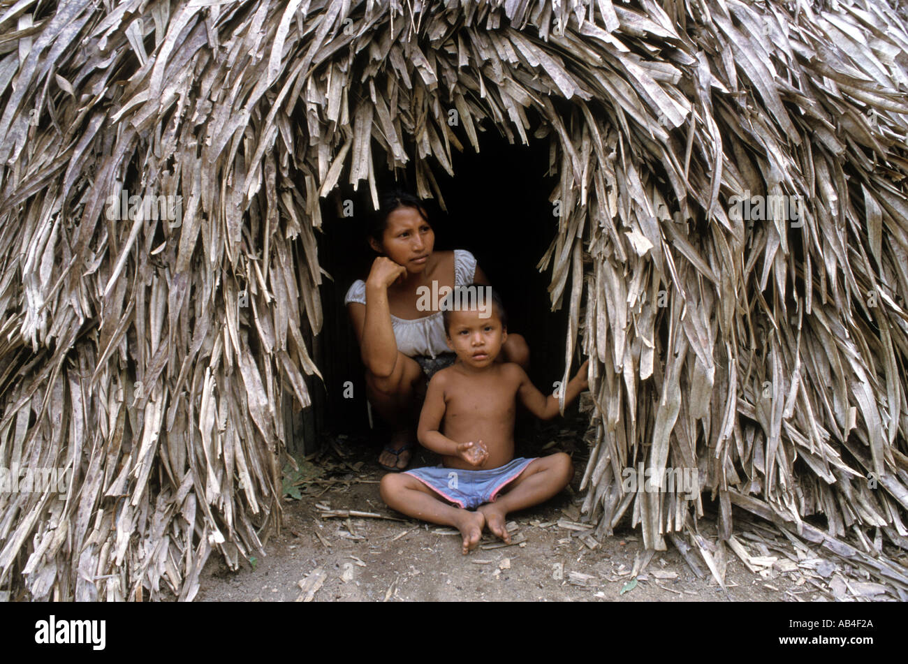 A Piaroa Indian woman and her son at the entrance to their thatched hut on the Rio Catanaipo near Puerto Ayacucho Venezuela  Stock Photo