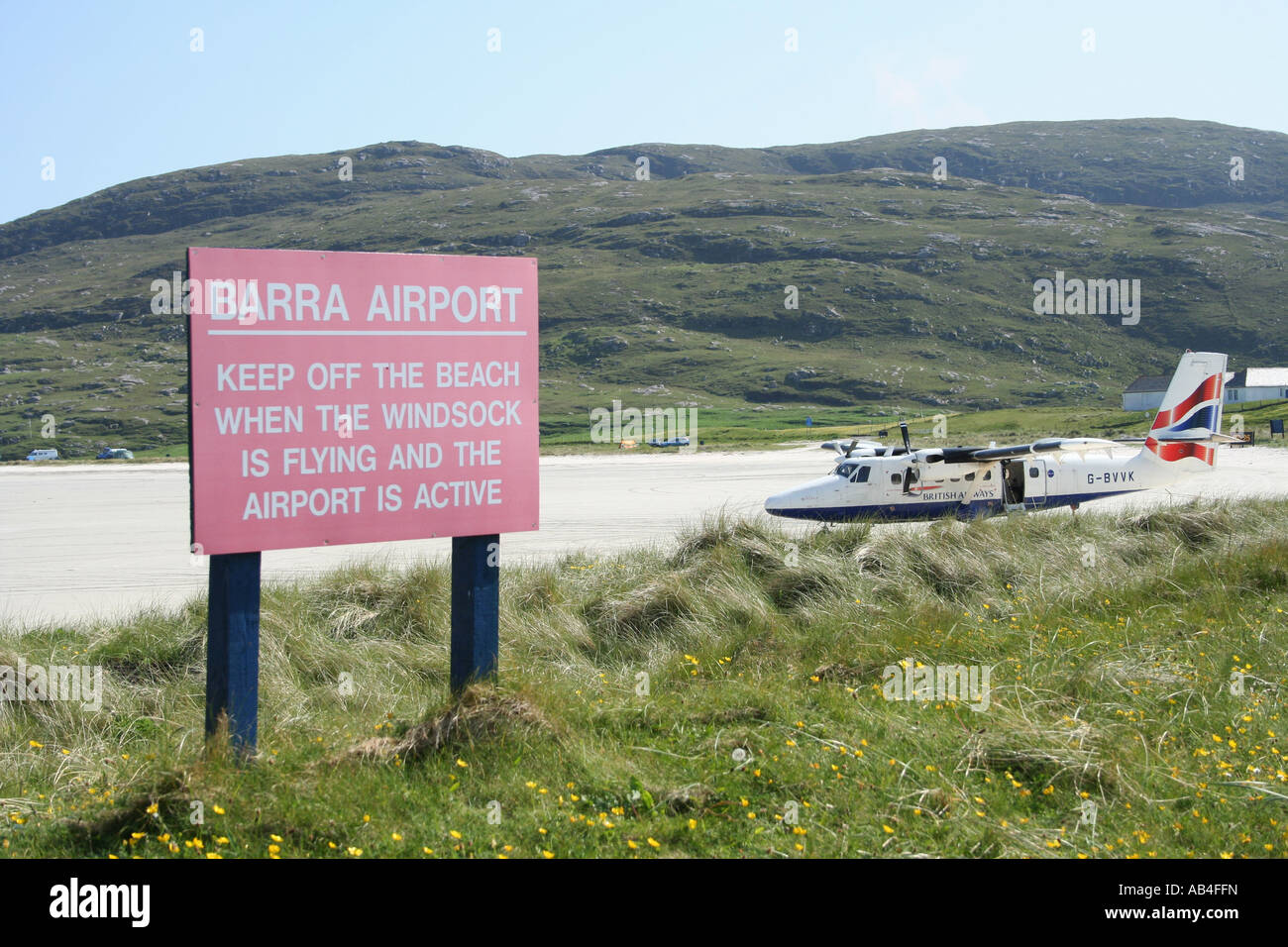 warning sign and propeller plane on beach runway Barra airport Isle of Barra Outer Hebrides Scotland  June 2007 Stock Photo