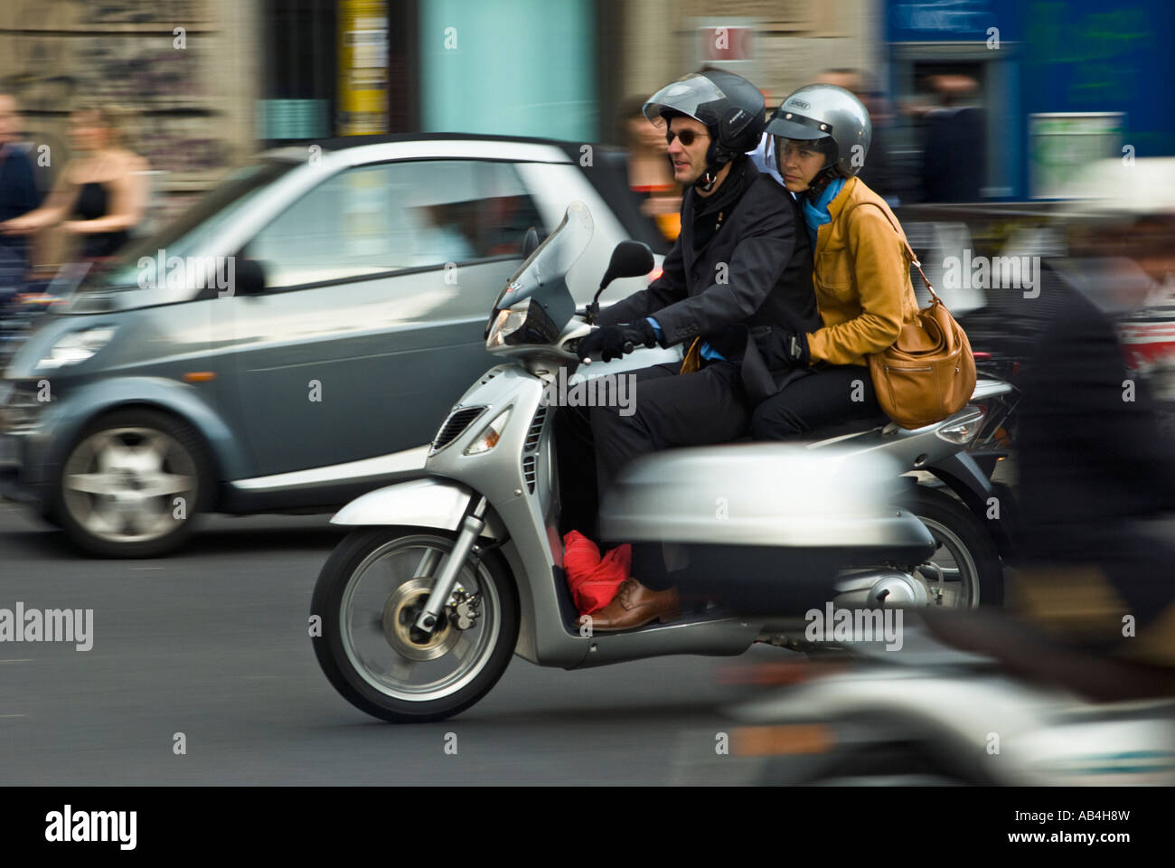 Couple on a scooter power down Corso Buenos Aires in the centre of Milan Stock Photo