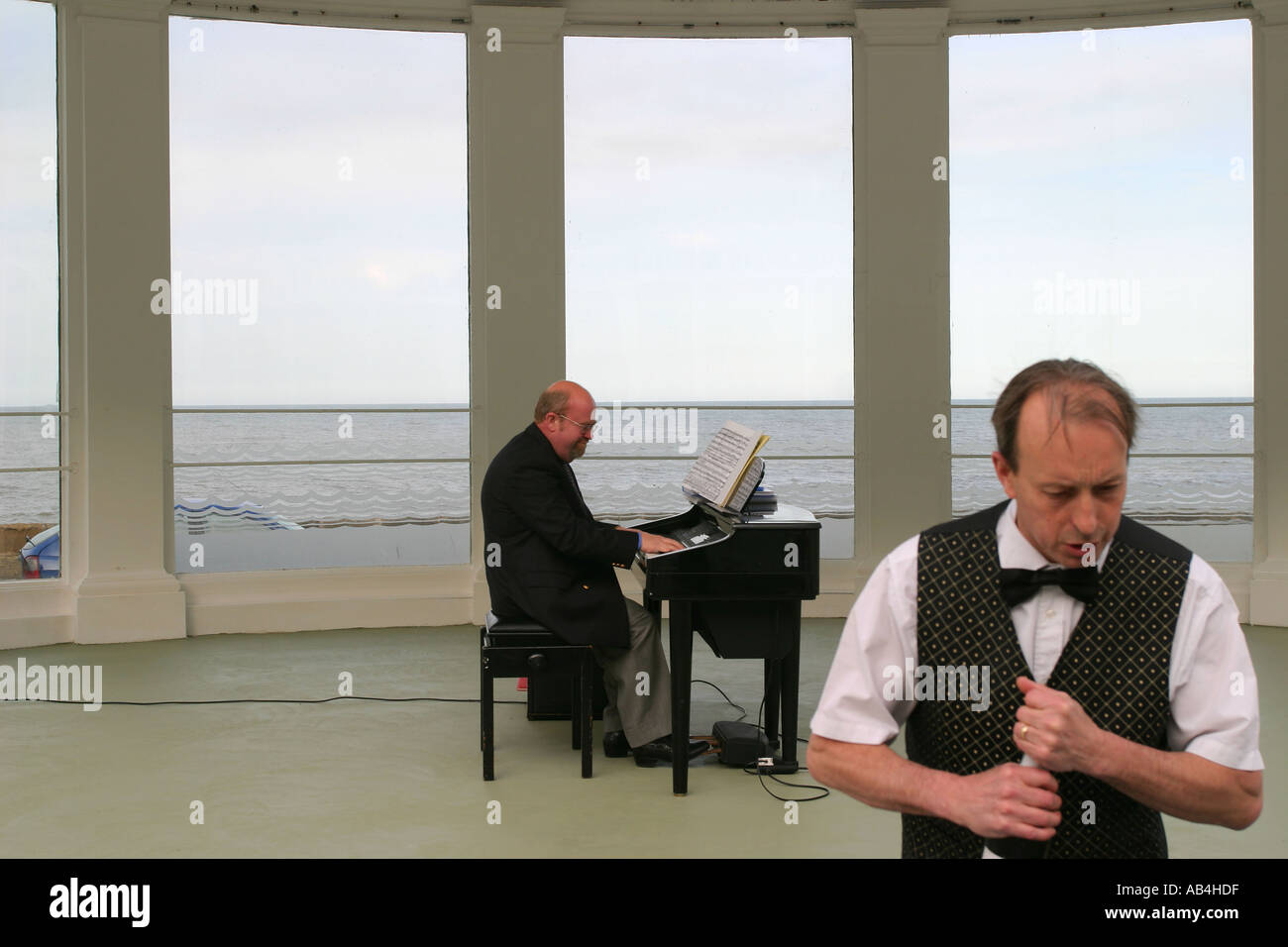 A waiter and a pianist at a hotel in Scarborough, Yorkshire, UK. Stock Photo