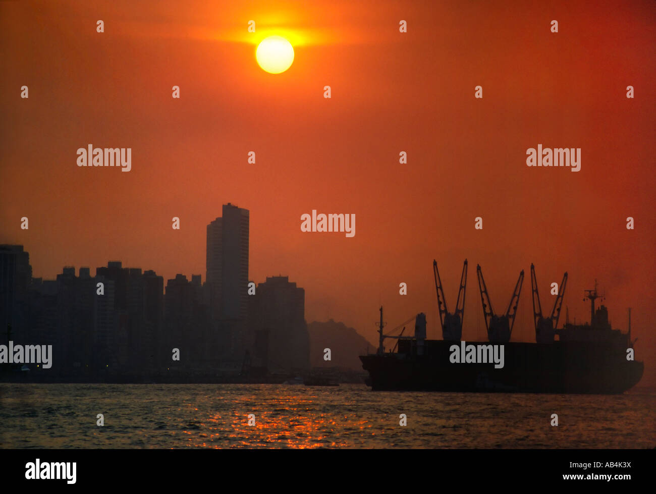 Hong Kong sunset with container ship Stock Photo - Alamy