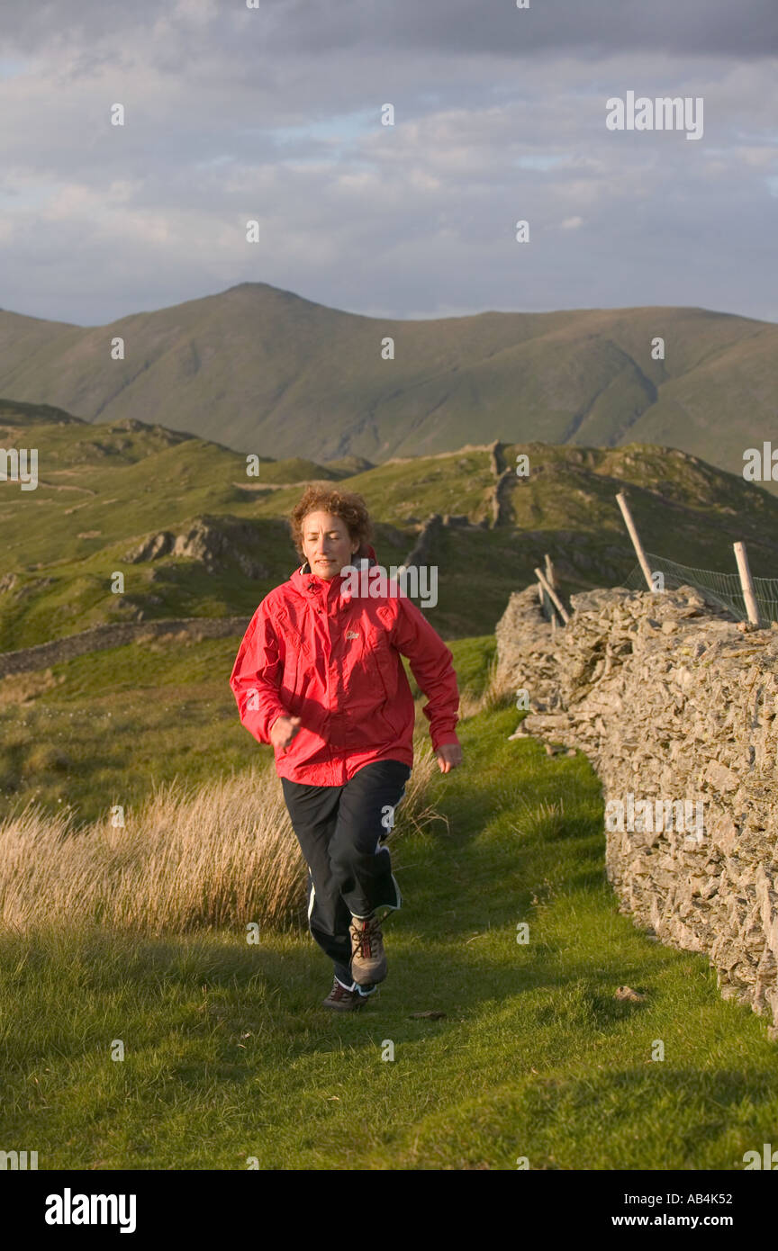 Fell runner running along the summit ridge of wansfell above Ambleside Lake district Stock Photo