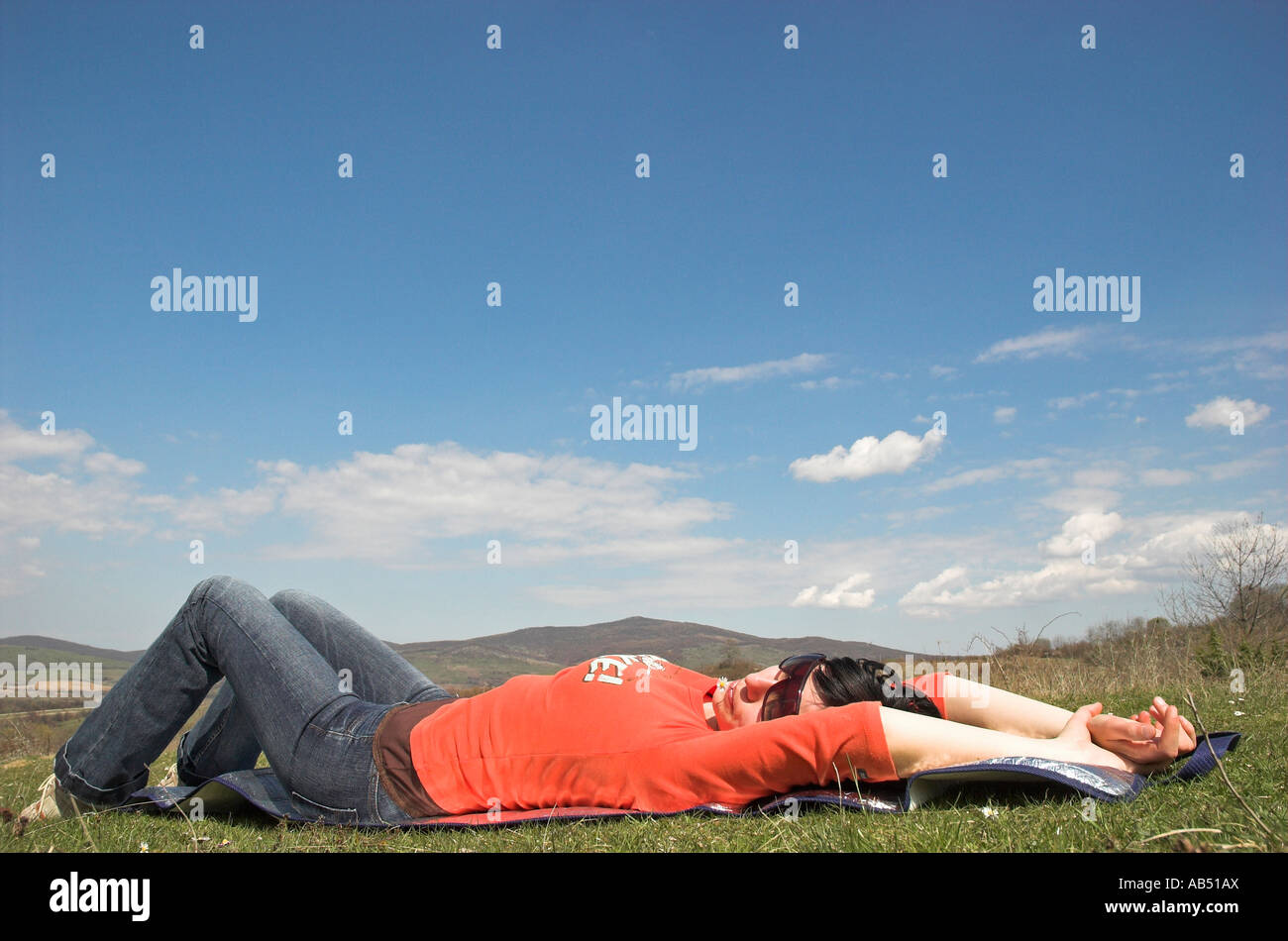 Young woman lying on grass spring Stock Photo - Alamy