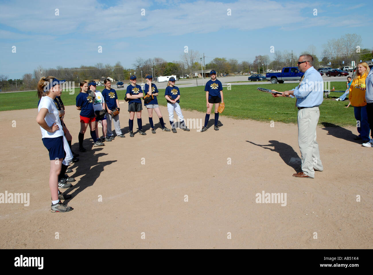 Softball coach explains the concept of bunting the ball to his middle school girls softball team Stock Photo