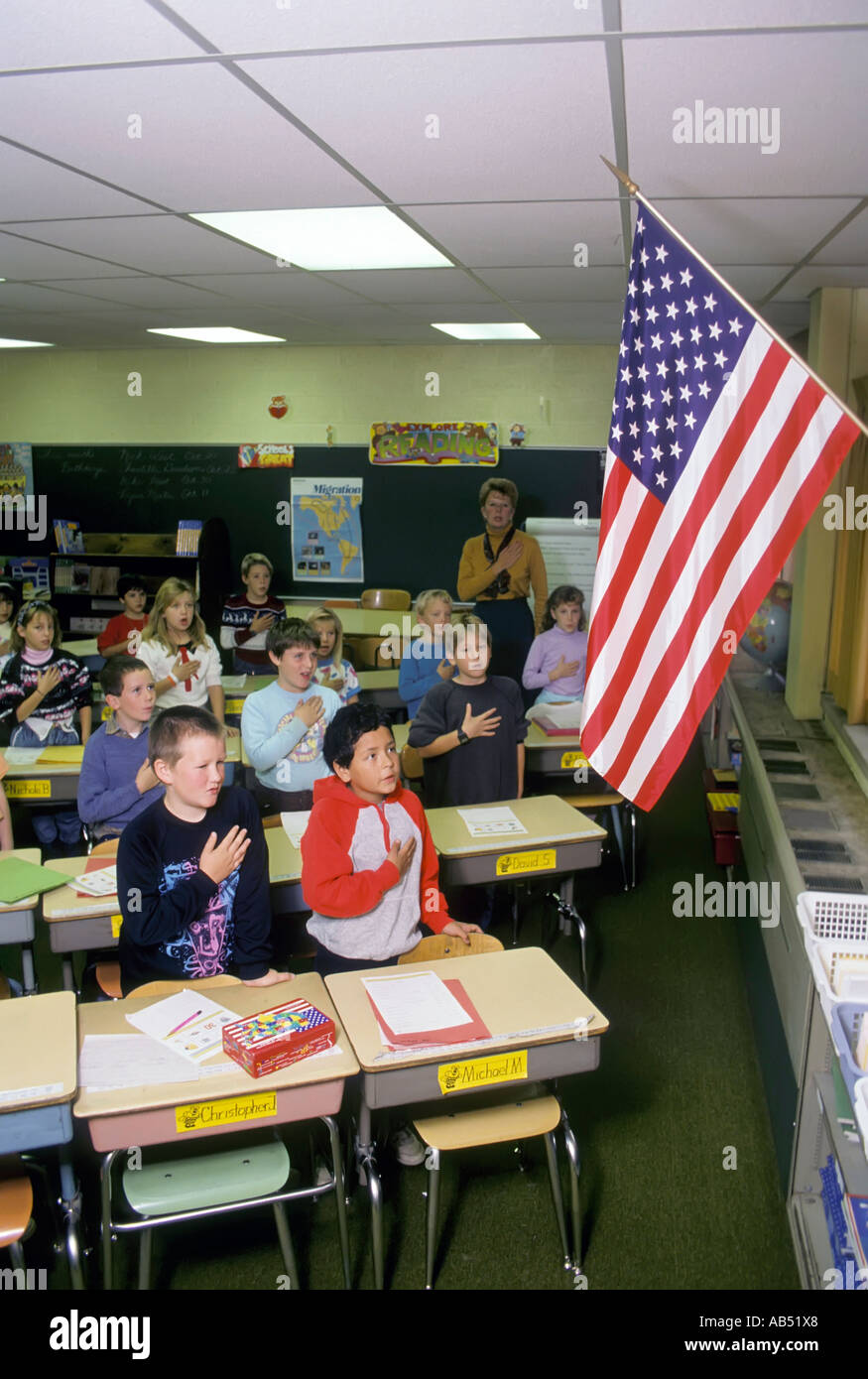 Third grade elementary school class recites the pledge of allegiance to the American flag every morning before beginning studies Stock Photo