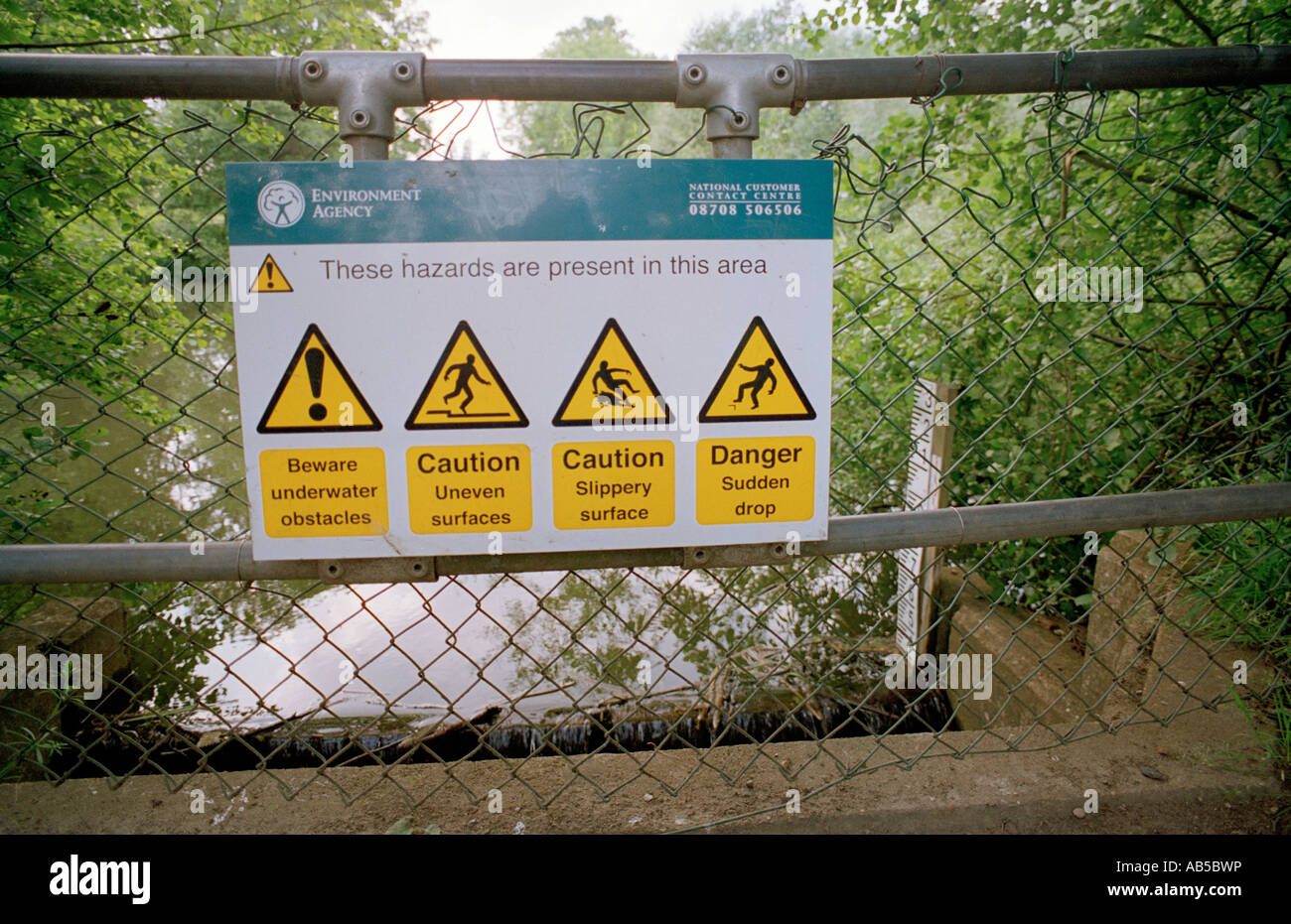 Hazard sign beside a weir on the Darent river, Westerham, Kent, England, UK. Stock Photo