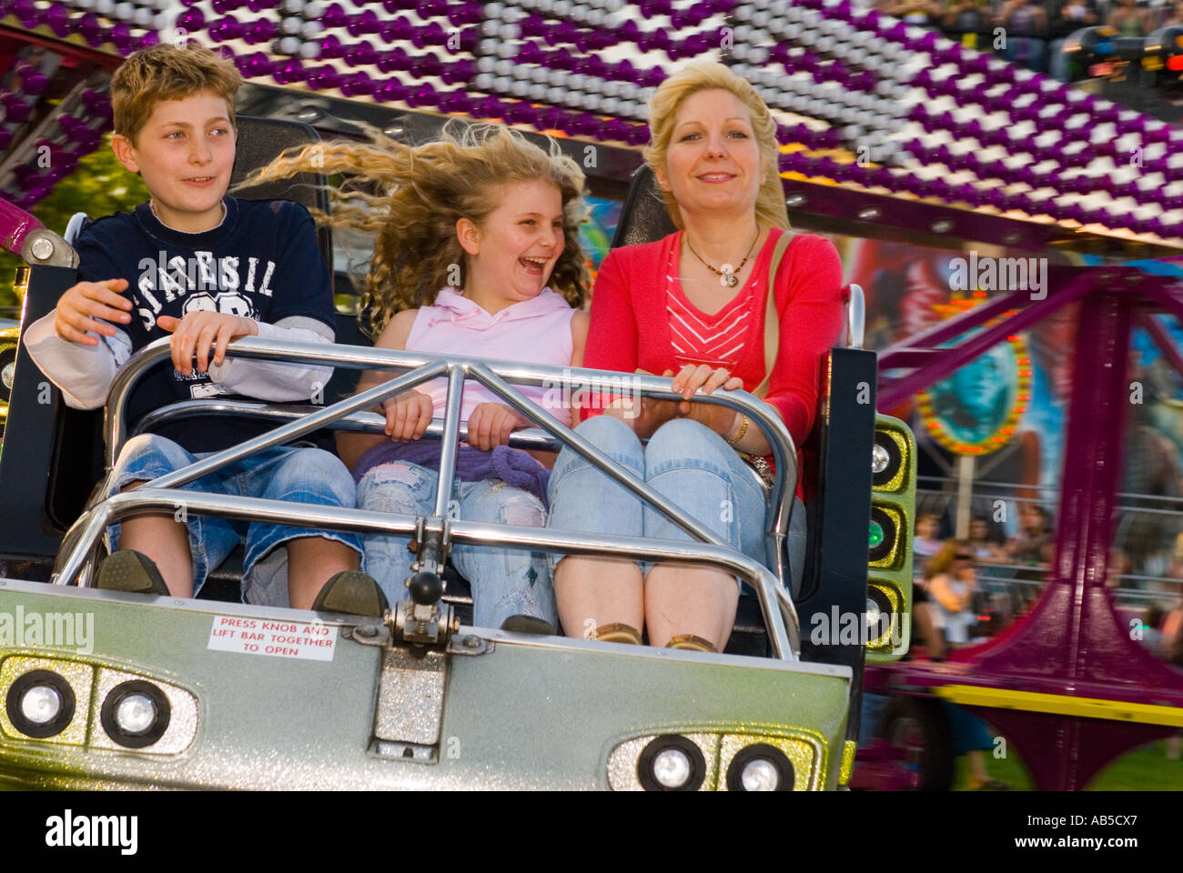 Mother, son and daughter on twister fairground ride Stock Photo - Alamy