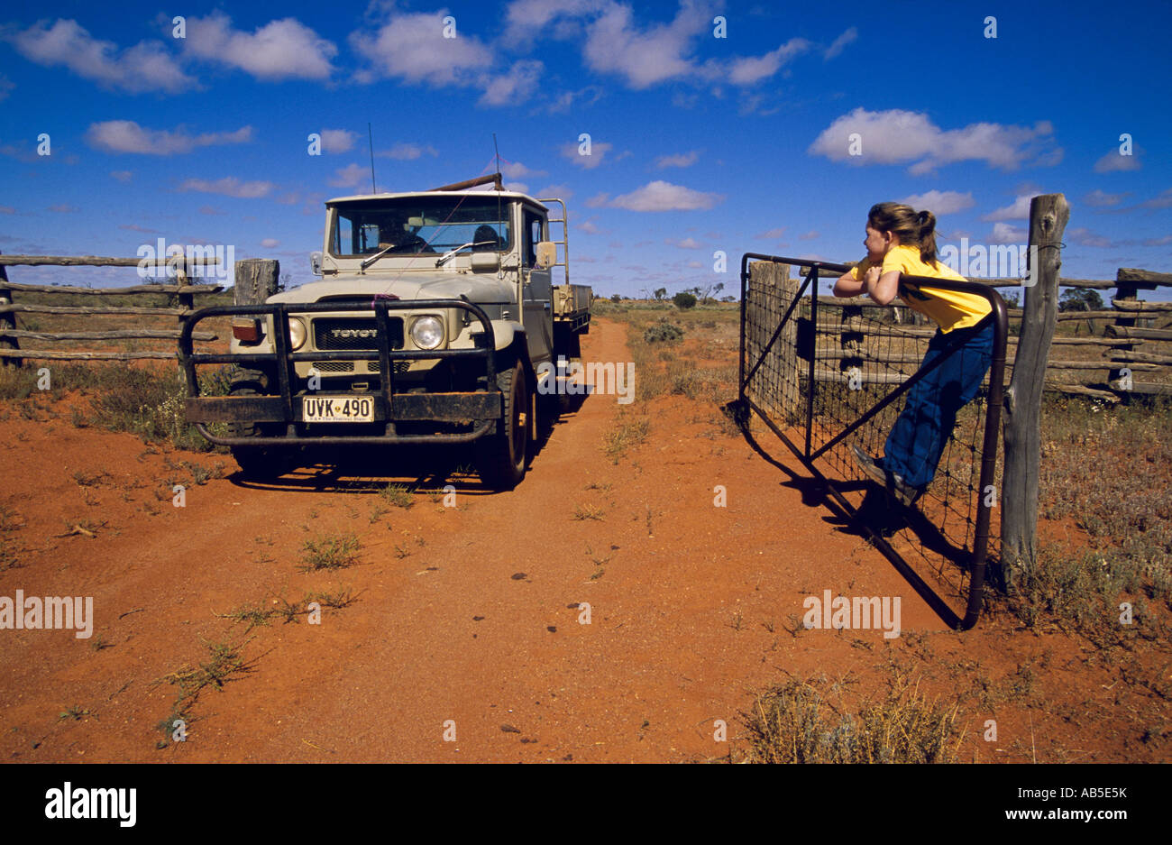 Young opening farm gate, Stock Photo -