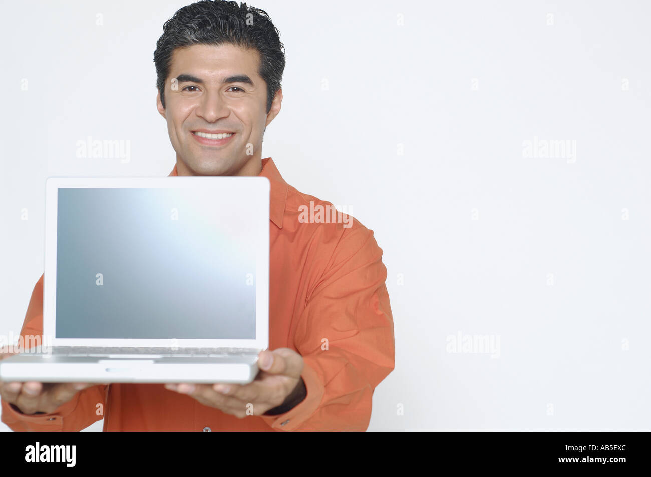 Young man holding out his laptop Stock Photo
