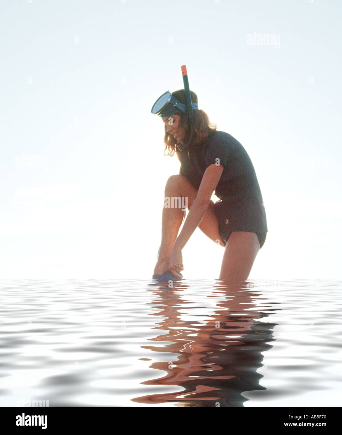 young woman putting on flippers for snorkling skin diving Stock Photo
