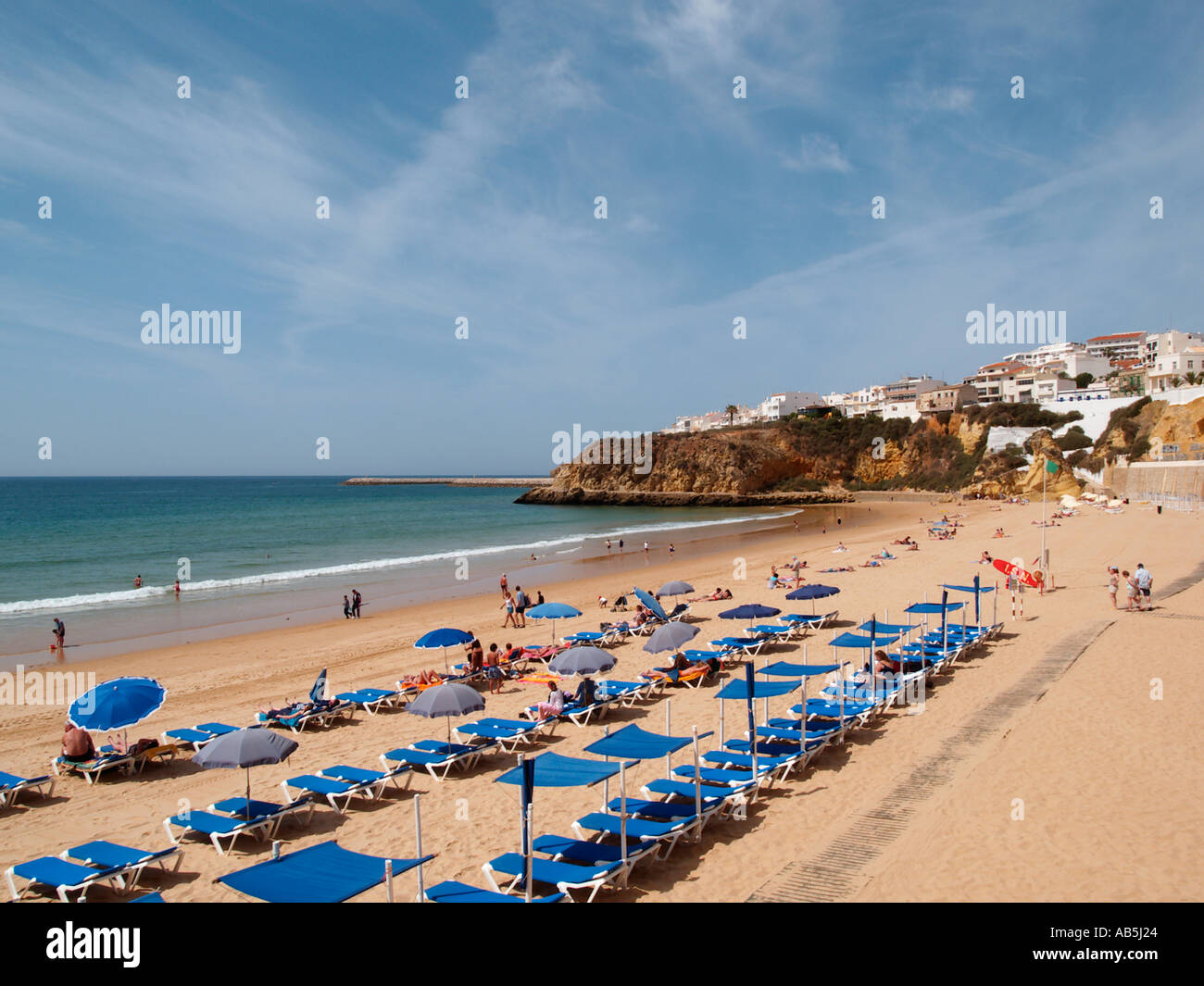 PRAIA DO PENCO beach below sandstone cliff with tourists and sunbeds on sandy beach. Albufeira Algarve Portugal Stock Photo