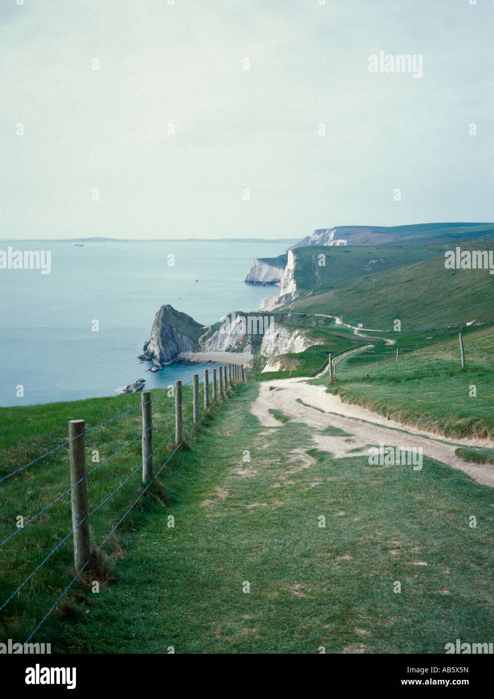 View west over Durdle Door peninsula, with white chalk cliffs beyond ...
