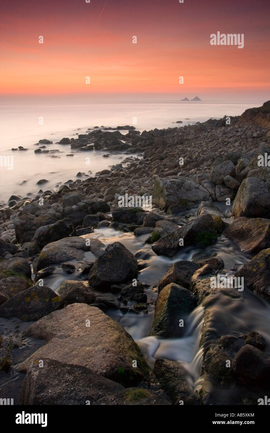 After sunset at Nanjulian Cove Cornwall UK with a river meeting the sea Stock Photo