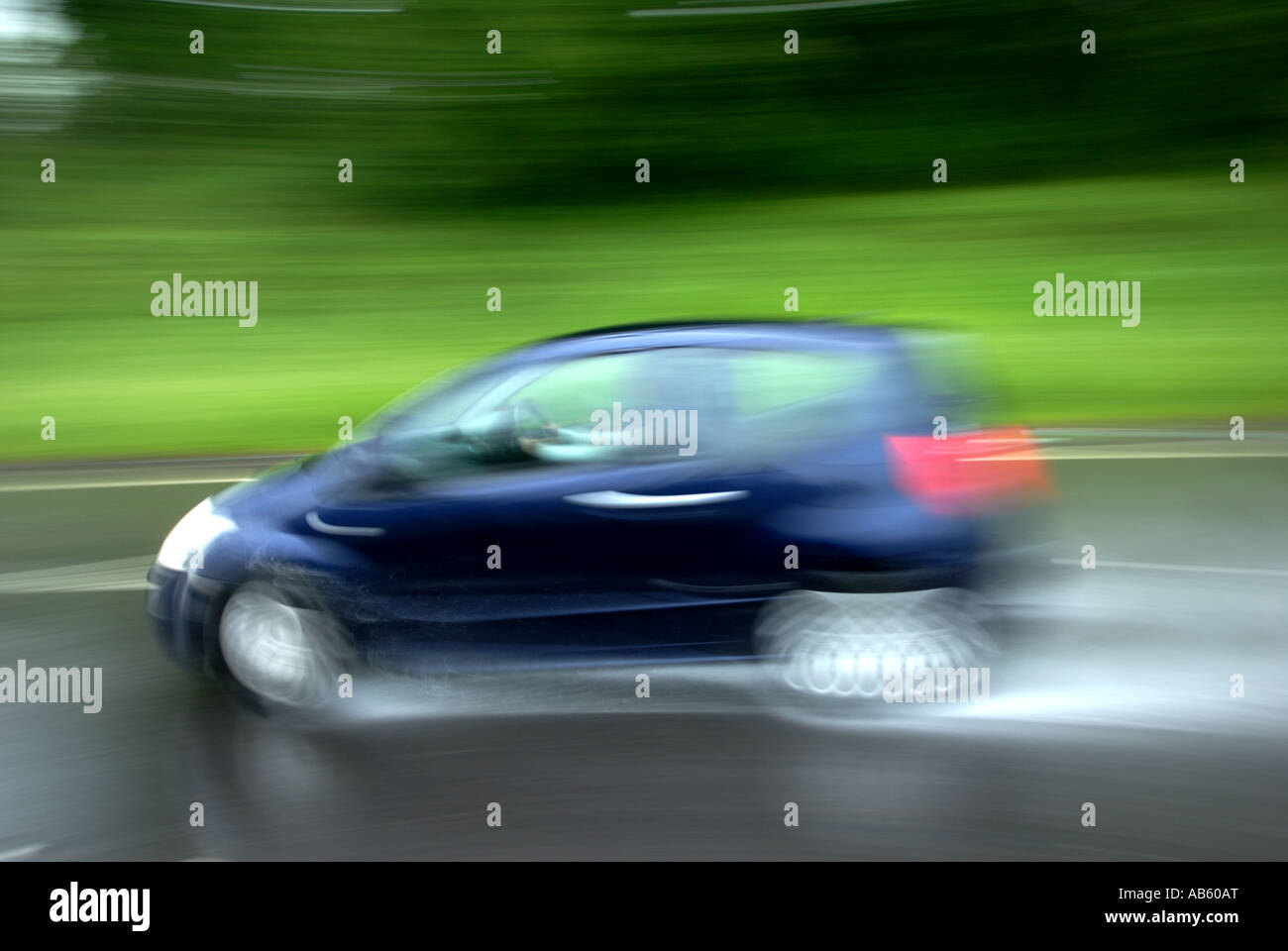 Car driving on wet road surface Stock Photo Alamy