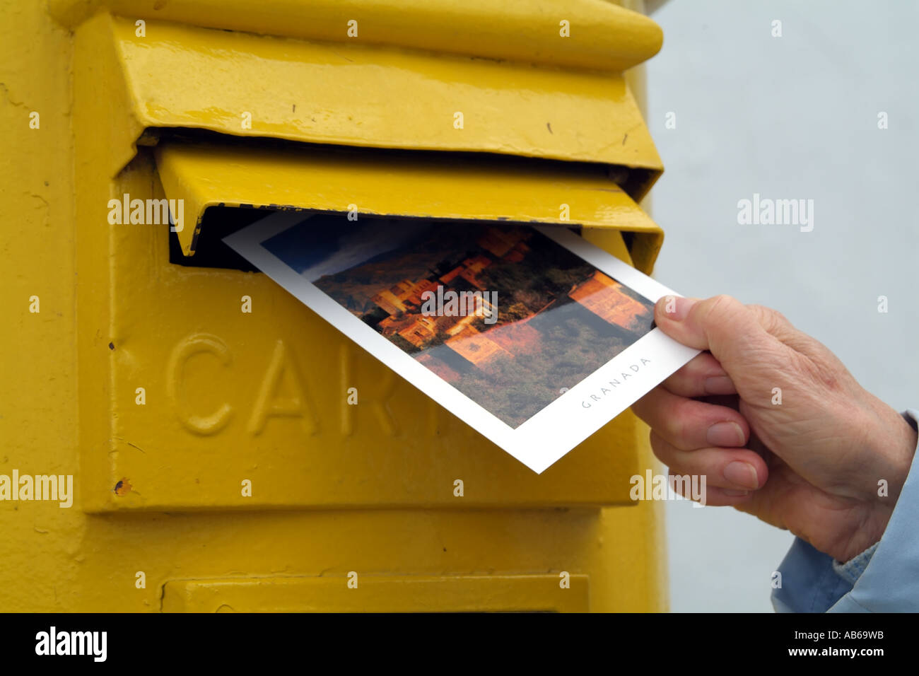 Greetings postcard being posted into Spanish letterbox. Spain Europe EU