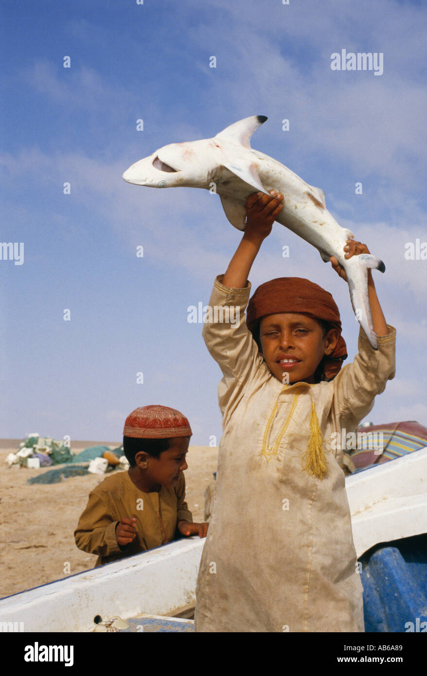 A local Bedu child holds up a caught fish Stock Photo