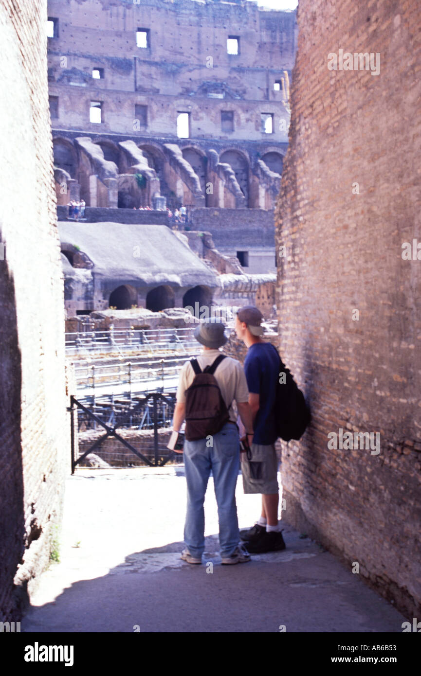 Two tourists with backpacks gazing at the Colosseum in Rome Italy Stock