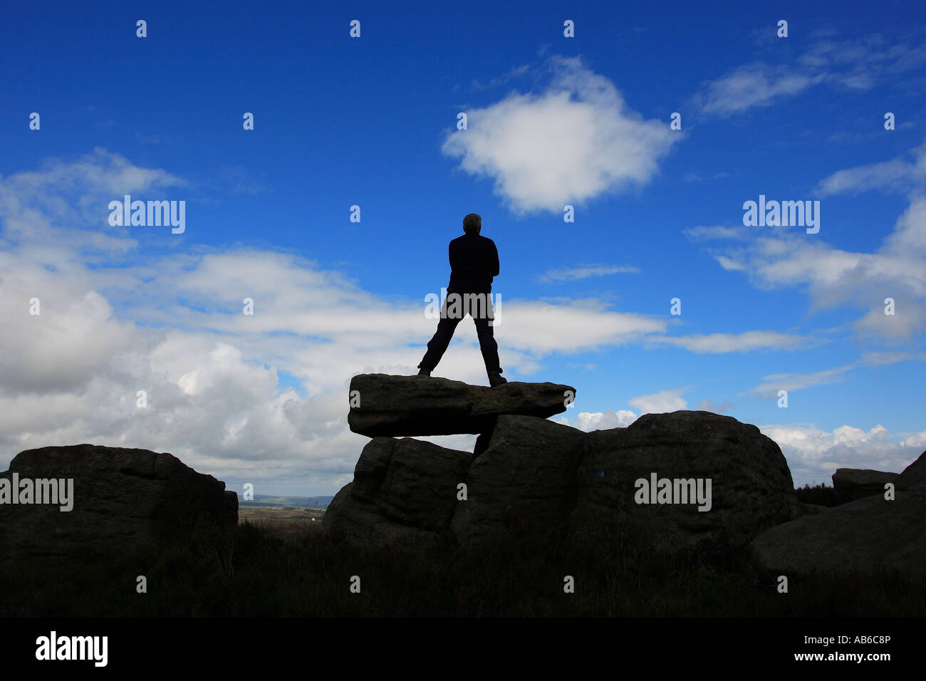 A walker stands on Alcomden Stones above Haworth in the South Pennines Stock Photo