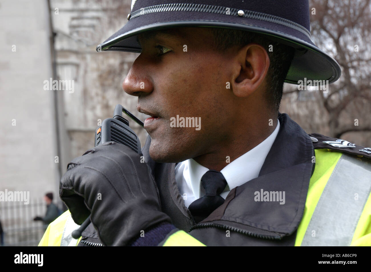 Black police officer talking on short band radio whilst on duty in Central London. Stock Photo