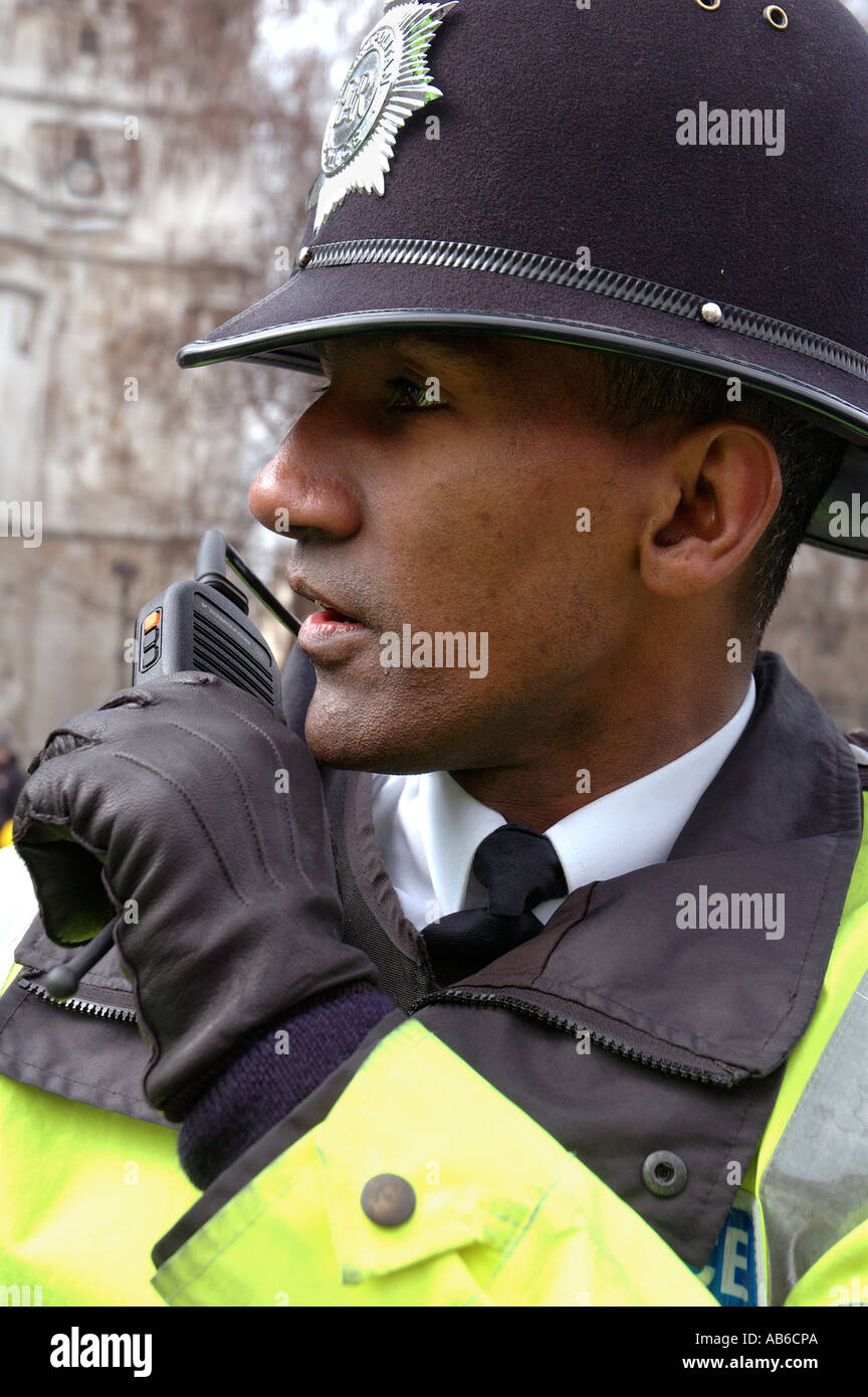 Black police officer talking on short band radio whilst on duty in Central London. Stock Photo