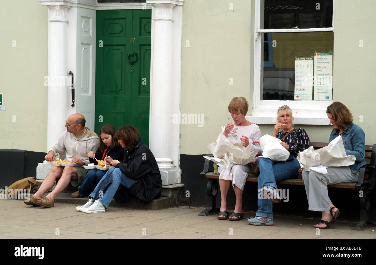 Visitors eating fried fish and chips in Alresford Hampshire southern England United Kingdom UK Stock Photo