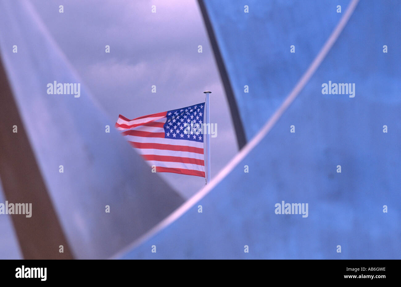 The American flag flies behind a memorial sculpture on Omaha beach. Stock Photo