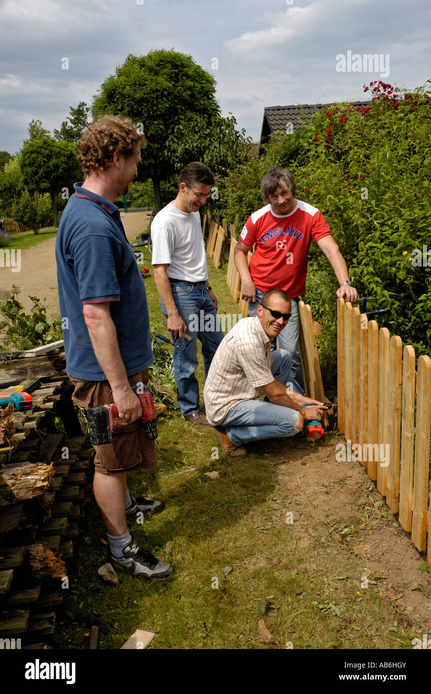 Handymen building a garden fence on allotments in Germany. Stock Photo