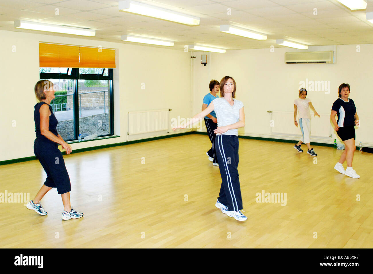 Females doing marching side step exercises in a workout class Stock