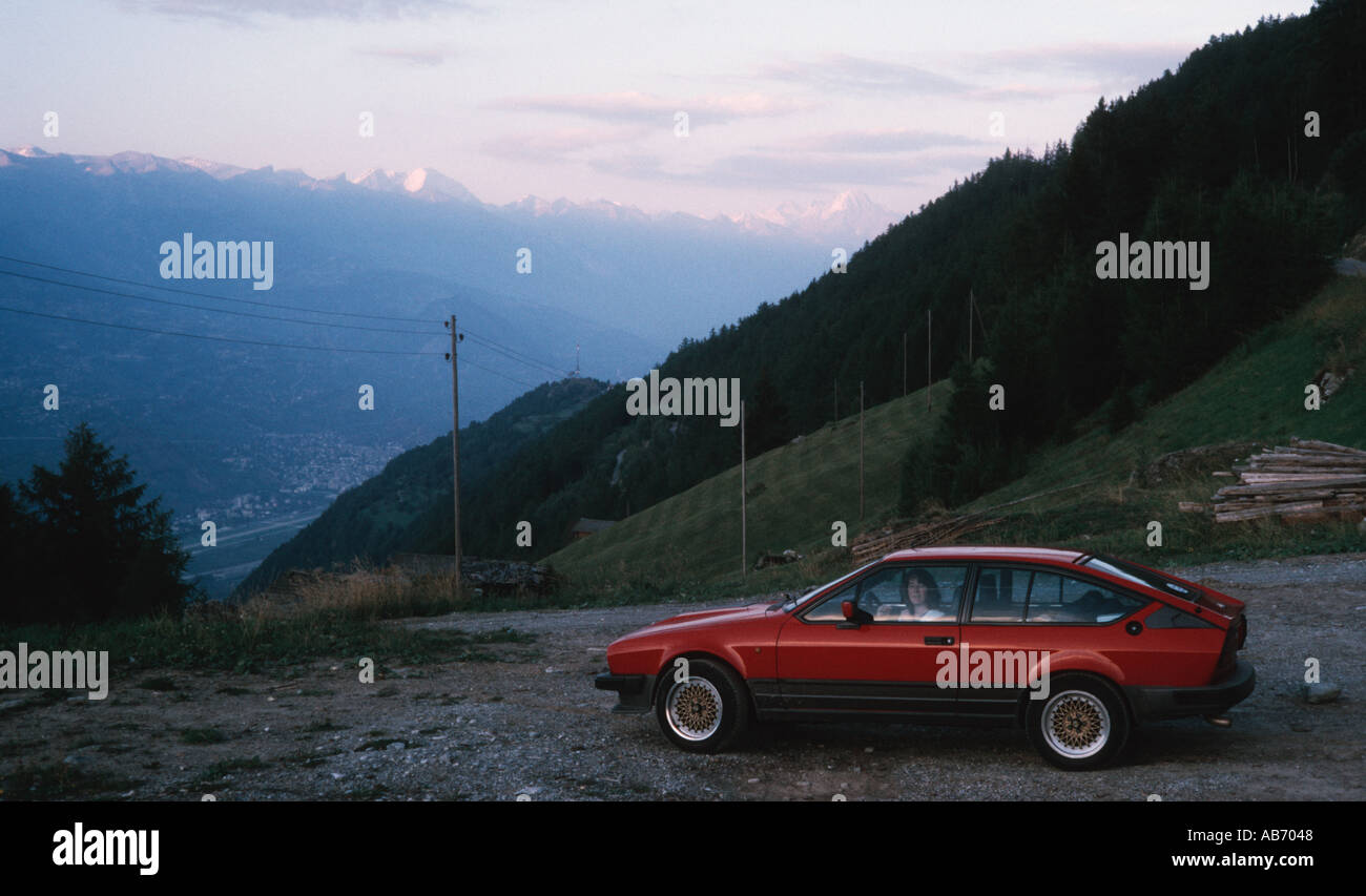 Alfa Romeo GTV6 1980s parked in the Swiss mountains a woman looks out of the car window Stock Photo