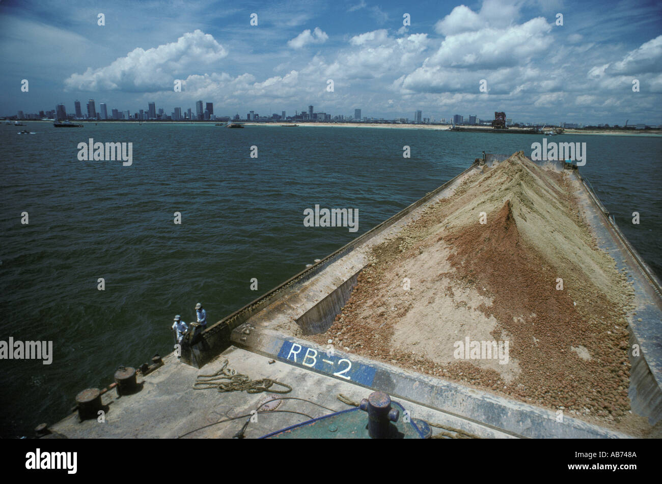 Singapore  Land reclamation earth put into huge barges and moved to different part of the island state. Circa September 1983 1980s HOMER SYKES Stock Photo