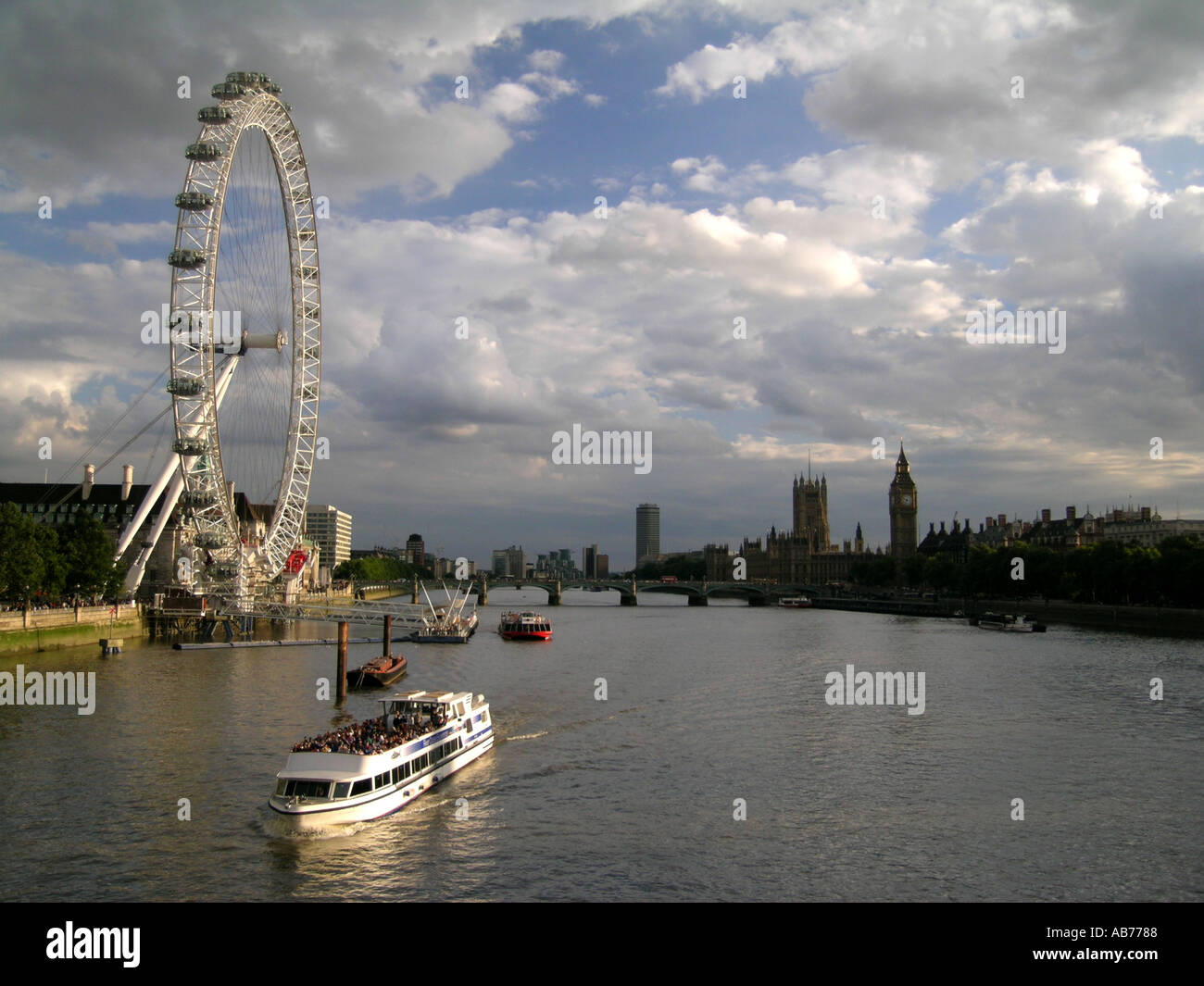 day The London Eye millenium ferris wheel and River Thames Boat London england britain UK Stock Photo