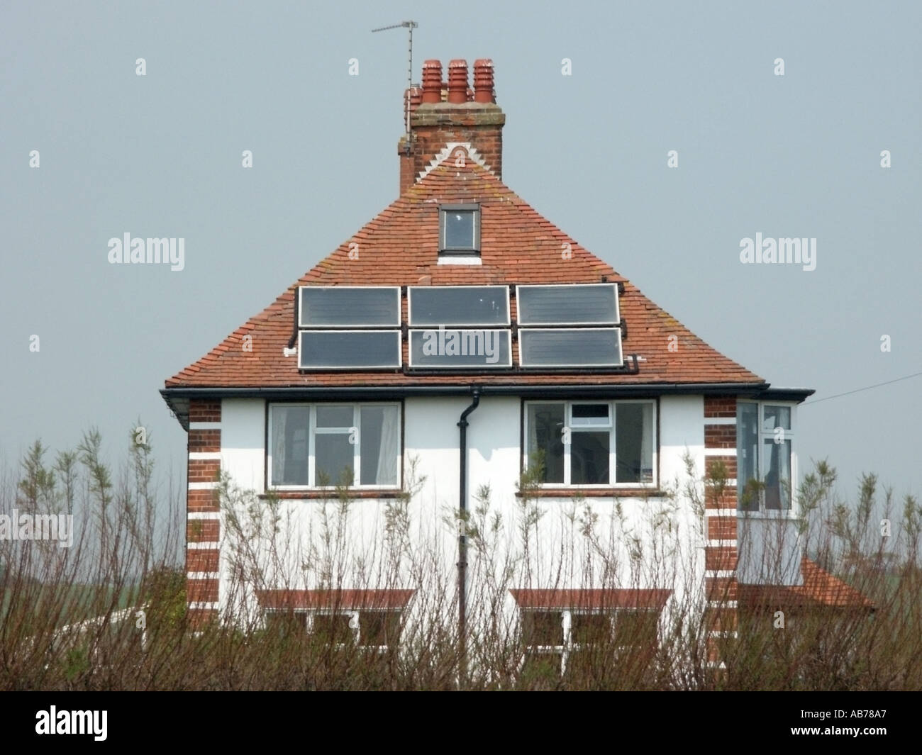 Suffolk East Anglia detached house with solar heat gathering panels on hipped roof Stock Photo