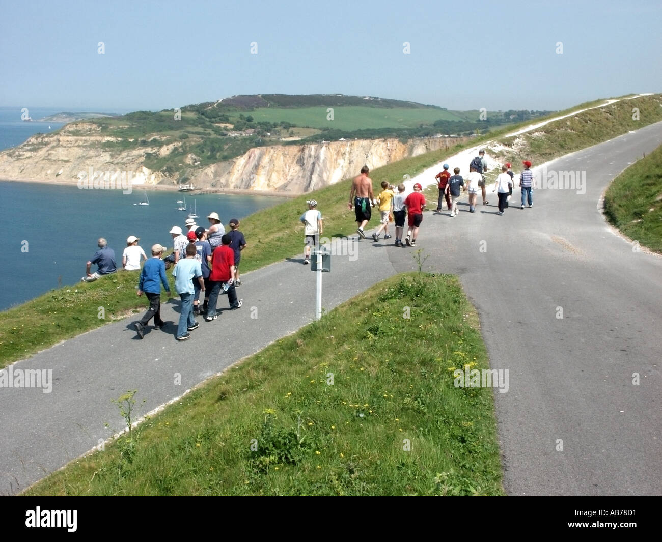 sle of Wight school children teachers walking along cliff top road toward the coloured sands of Alum Bay Stock Photo