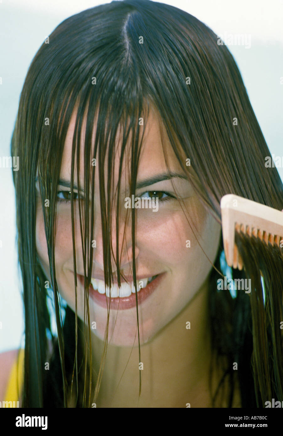 Woman combing her hair Stock Photo