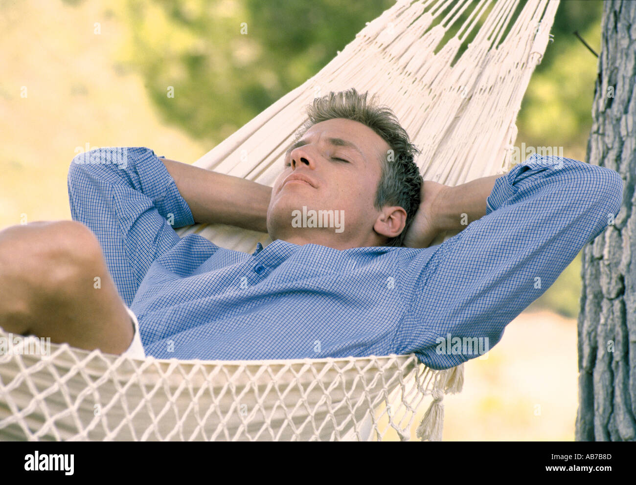 Man lying in hammock Stock Photo