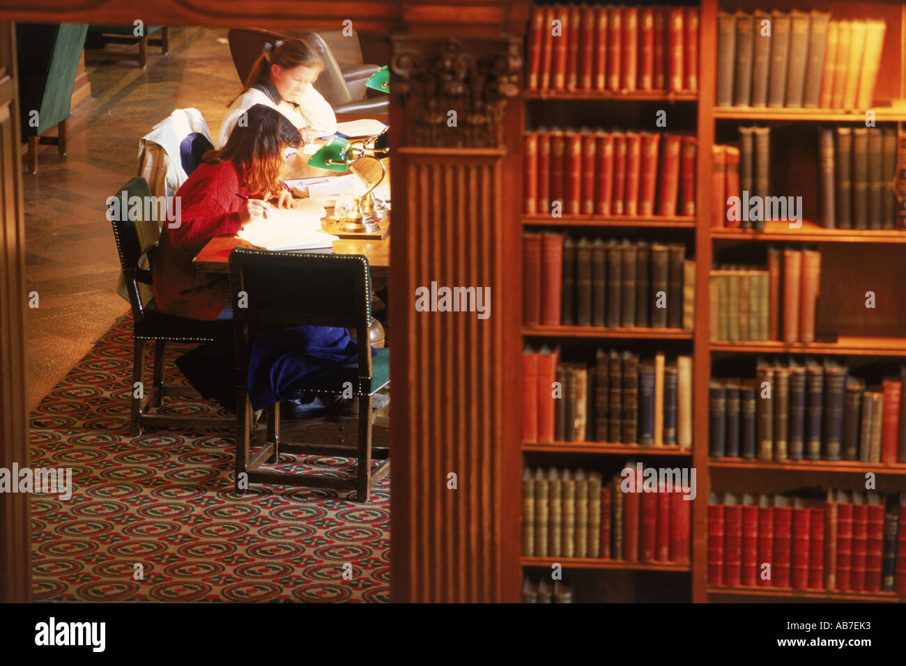 Two students in Dartmouth College Library with workbooks and pens under lamplight Stock Photo